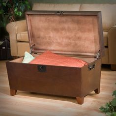 an open suitcase sitting on top of a hard wood floor next to a chair and couch