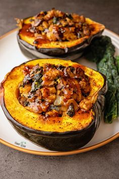 two baked delicacy dishes on a plate with spinach and other food items