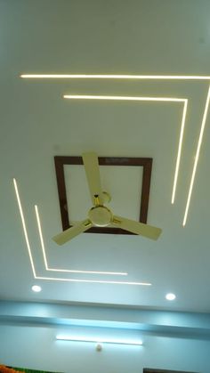 the ceiling fan is hanging from the ceiling in this room with white walls and lights