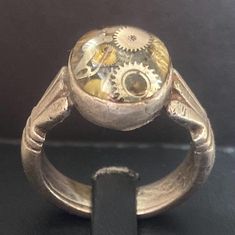 Make a bold statement with our Daring Steampunk Men's Ring, crafted from textured metal and featuring striking gear accents. This eye-catching piece blends rugged charm with intricate detailing, perfect for the modern man who embraces individuality. Ideal for both everyday wear and special occasions, it's a must-have for any steampunk enthusiast! Steampunk Jewelry Rings, Antique Gold Steampunk Metal Jewelry, Steampunk Mechanical Rings, Steampunk Metal Jewelry Vintage Collection, Gold Steampunk Nickel-free Jewelry, Steampunk Man, Men's Ring, Modern Man, Rings Statement