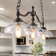 three light fixtures hanging from the ceiling in a kitchen