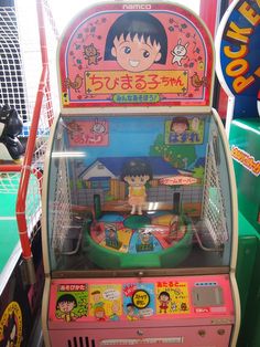 an old fashioned arcade machine with cartoon characters on the front and back sides, in a toy store