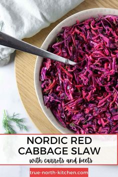 Nordic Red Cabbage Slaw in a bowl with a spoon next to a napkin and dill sprigs.