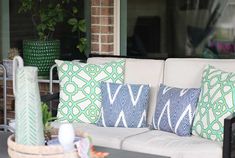 a couch sitting on top of a patio covered in pillows