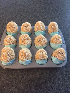 there are many cupcakes with faces on them in the pan, ready to be eaten