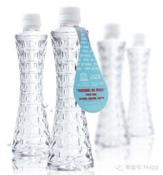 three clear water bottles are lined up next to each other on a white surface, one is empty and the other has a blue label