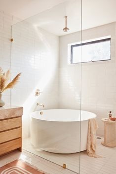 a white bath tub sitting in a bathroom next to a window