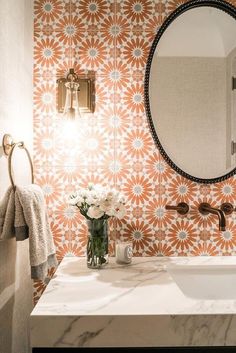 a white sink sitting under a bathroom mirror next to a wall mounted faucet