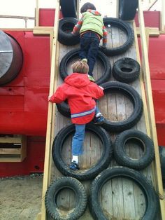 two children playing on a train made out of tires