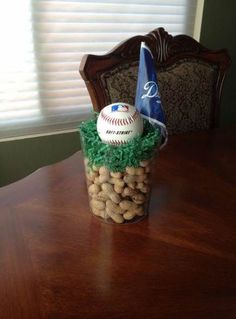 a table with a baseball, ball and flag in it on top of some peanuts