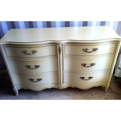 a white dresser with gold handles and drawers