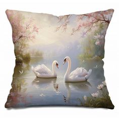 two white swans swimming in the water on a pillow