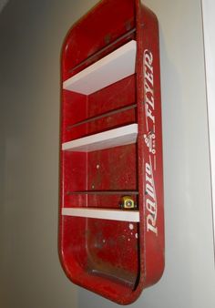 a red wall mounted shelf with white shelves