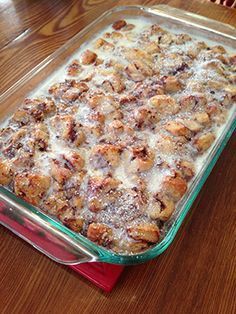 a casserole dish is sitting on a wooden table and ready to be eaten