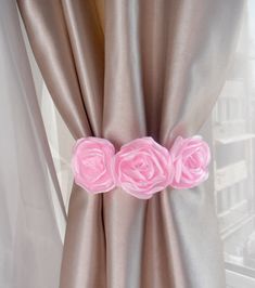 pink roses are attached to the side of a curtain