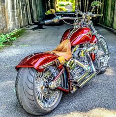 a red motorcycle parked in front of a wooden fence