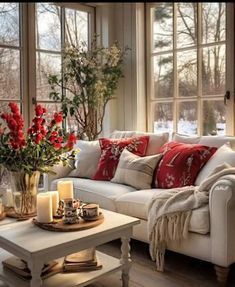 a living room filled with white furniture and red pillows