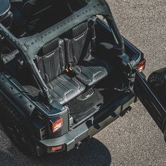 the back end of a black jeep with seats and luggage in it's trunk