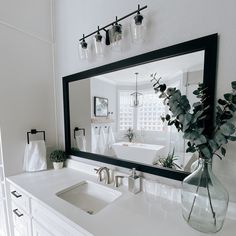 a bathroom with a large mirror, sink and bathtub