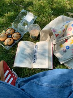 an open book and some muffins on the grass