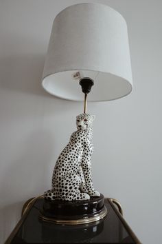 a lamp that is sitting on top of a table next to a cheetah figurine