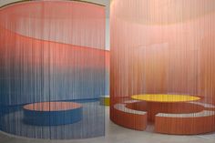 two large round tables in front of colorful walls