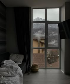 a bed sitting next to a window with a mountain view in the backround