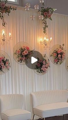 a room with white couches and flowers on the wall