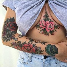 a woman with tattoos on her stomach and arms is holding onto the back of her body