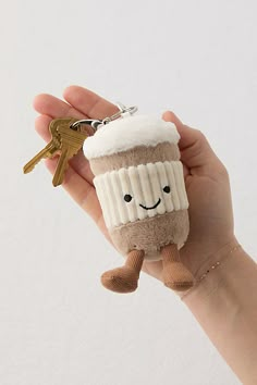 a hand holding a keychain shaped like a cupcake