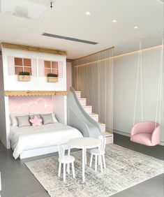 a bedroom with pink and white furniture in the corner, including a slide for children's play