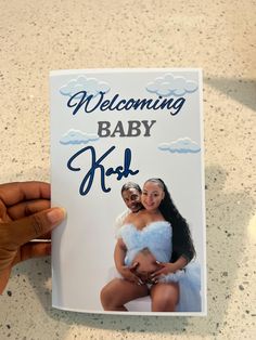 a person holding up a baby card with the words, welcome baby kid on it