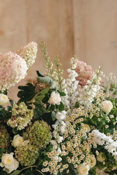 a vase filled with lots of white and pink flowers