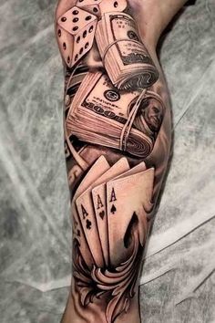 a man's arm with playing cards and dice tattoo on the leg, done by person