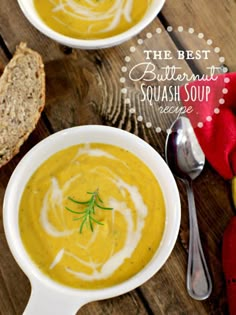 two bowls of butternut squash soup on a wooden table with bread and spoons