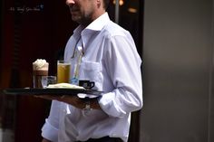 a man holding a tray with drinks on it