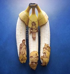 two bananas with pictures on them sitting on a blue surface, one is cut in half and the other has been peeled