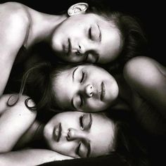 three young women are laying down together in black and white, with their heads resting on each other's shoulders