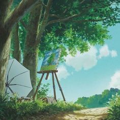 an artist's easel sitting in the grass next to a tree and umbrella