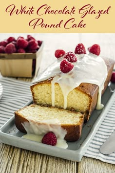 a white chocolate glazed pound cake on a plate with raspberries and icing