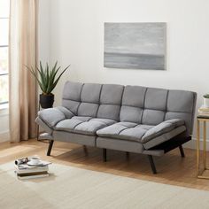 a living room with a black couch and white rug