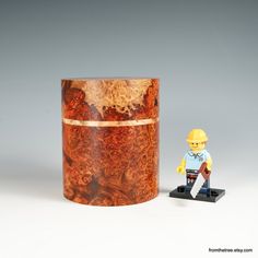 a lego man standing next to a wooden container