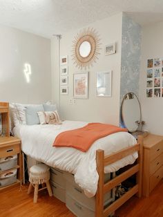 a bed room with a neatly made bed and dressers next to it on a hard wood floor