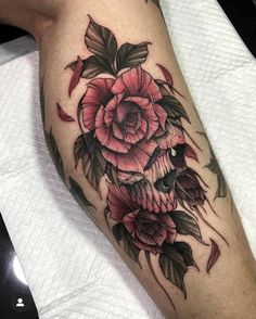 a skull and flowers tattoo on the leg