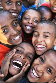 a group of young children standing next to each other with their mouths open and smiling