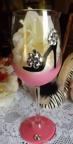 a wine glass decorated with high heels and flowers