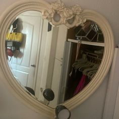 a mirror that is hanging on the wall next to a coat rack and closet door