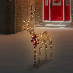 a lighted reindeer in front of a red door