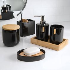 Add an updated contemporary touch to your bathroom with the Haven Soap Dish by Allure Home Creation. The oval shape of this minimalist design is featured in a rich shiny black finish with a slotted light bamboo insert inset into the base. This dish is made of ceramic with a raised edge. This versatile piece can be used to hold a standard size bar of soap or as a convenient spot to place your jewelry or other trinkets. This classic accessory will dress your bathroom with sophisticated style. Use Bathroom Lights Black, Black And Chrome Bathroom Fixtures, Bachelor Lifestyle, Bamboo Divider, Black Bathroom Fixtures, Bathroom Tumbler, Bathroom Retreat, Ball Jar, Liquid Hand Soap