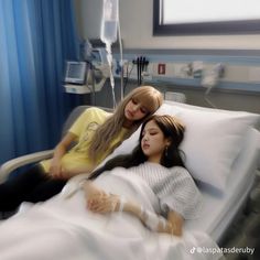 two young women laying in a hospital bed